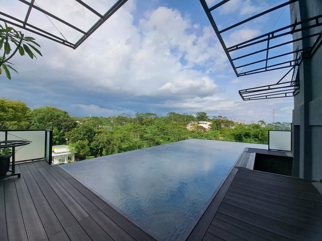 Kolam renang infinity edge di villa pribadi saat senja